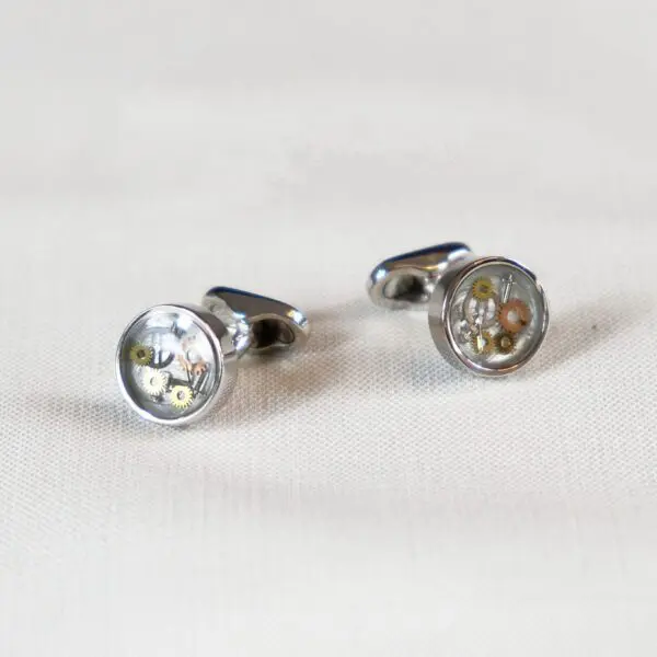 A pair of cufflinks with the image of a flower.