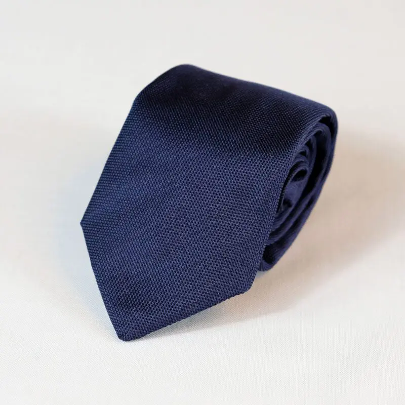 A blue tie is laying on the floor.