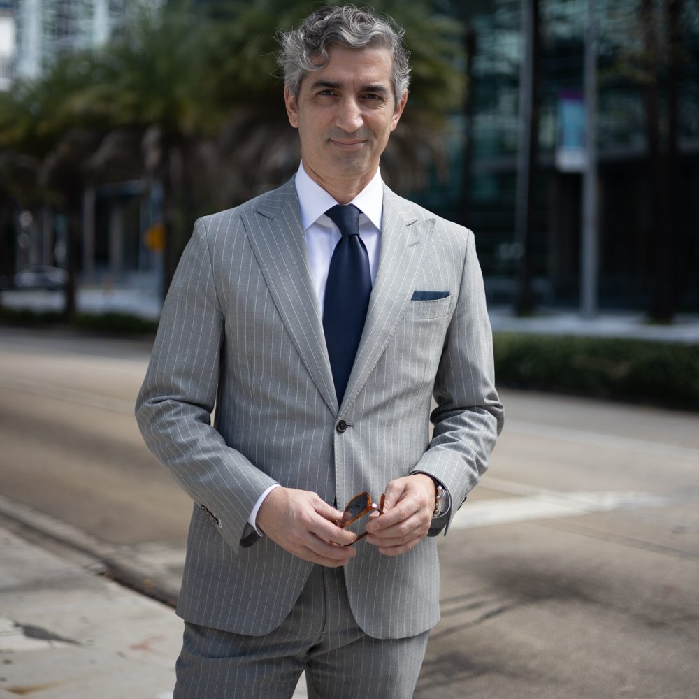 A man in a suit and tie standing on the side of a road.