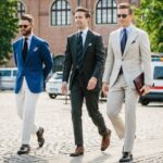 Three men in suits and ties walking down a street.