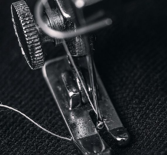 A sewing machine is shown with its foot on the needle.