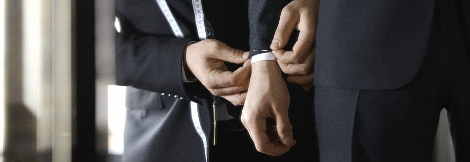 A man tying another mans tie on his suit.
