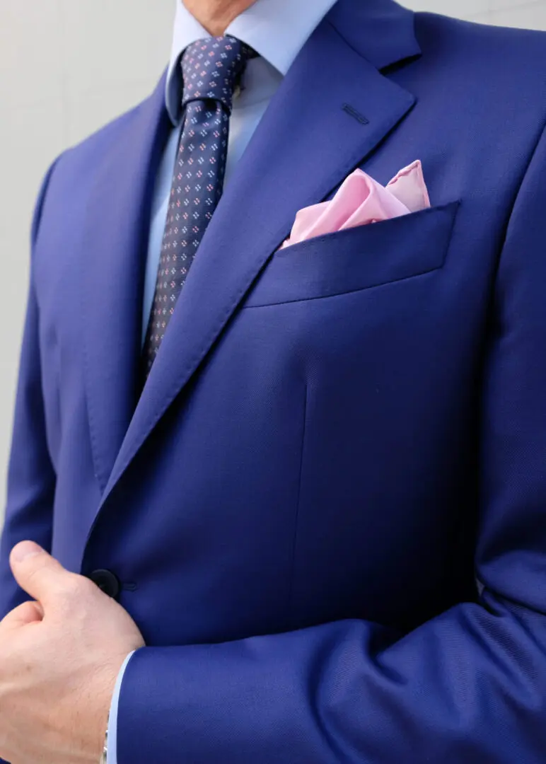 A man in a suit and tie with his hands crossed.