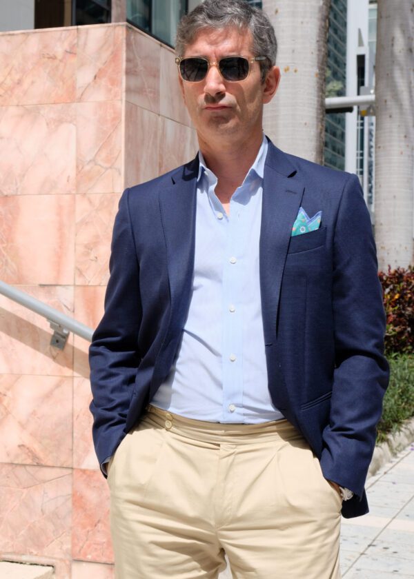 A man in a suit and tie standing outside.