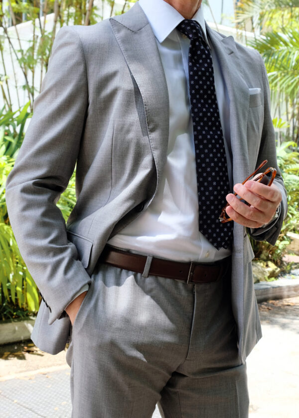 A man in a suit and tie holding a cell phone.