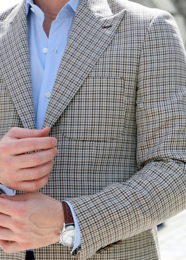 A man in a suit and tie holding his hands together.