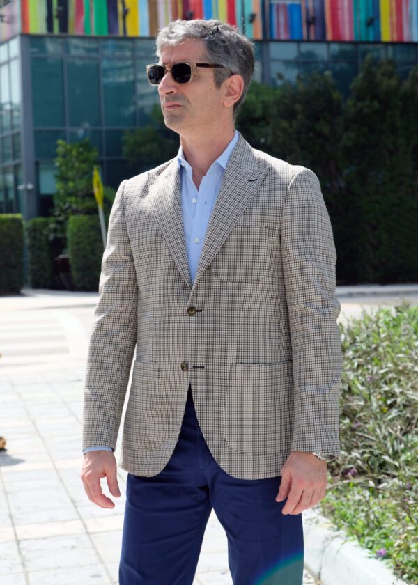 A man in a suit and tie standing outside.