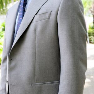 A man in a suit and tie standing outside.