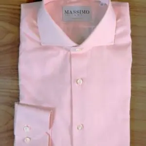 A pink shirt is laying on the table