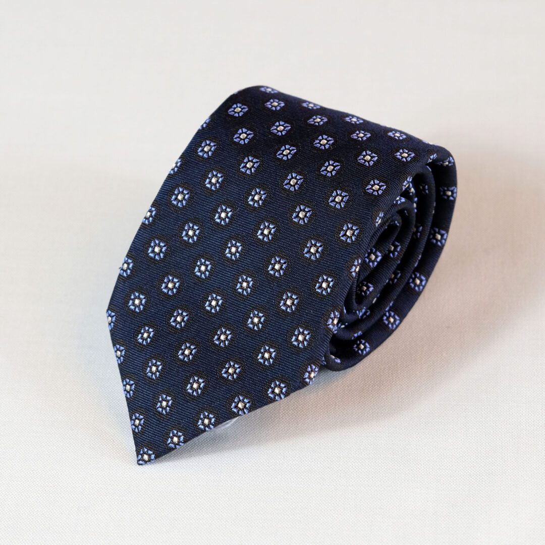 A tie with small white flowers on it.