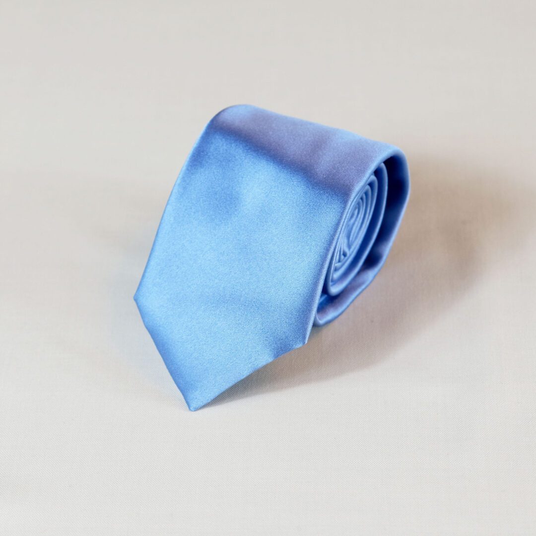 A blue tie is laying on the floor