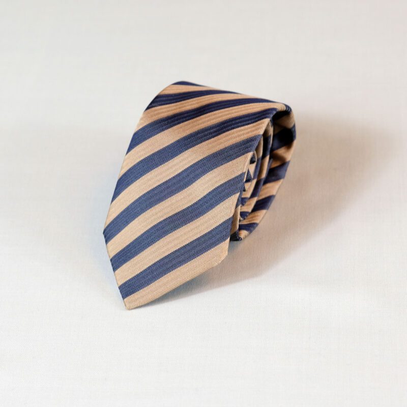 A striped tie is laying on the ground.