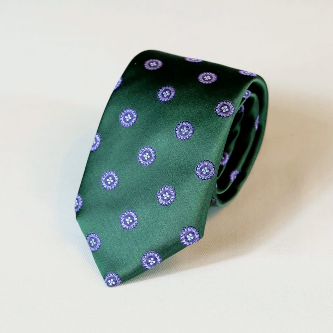 A green tie with blue and white circles on it.