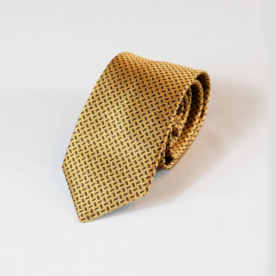 A gold tie with black squares on it
