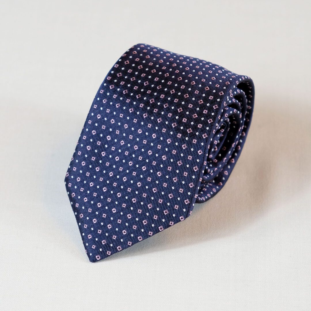 A blue tie with pink and white dots on it.