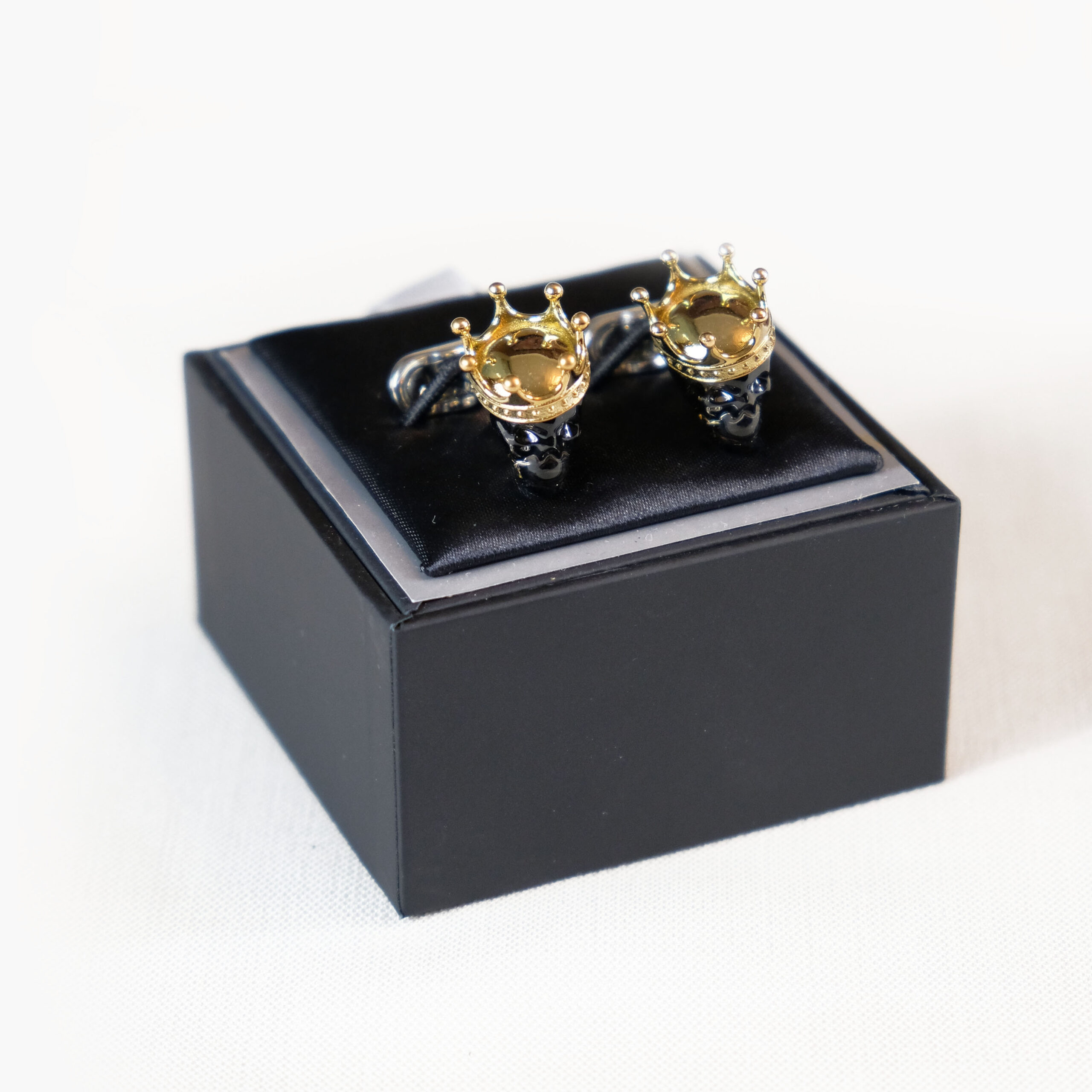 A black box with two gold plated cufflinks.