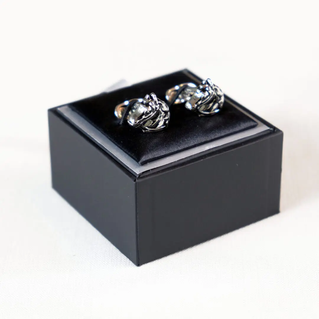 A black box with two cufflinks on top of it.