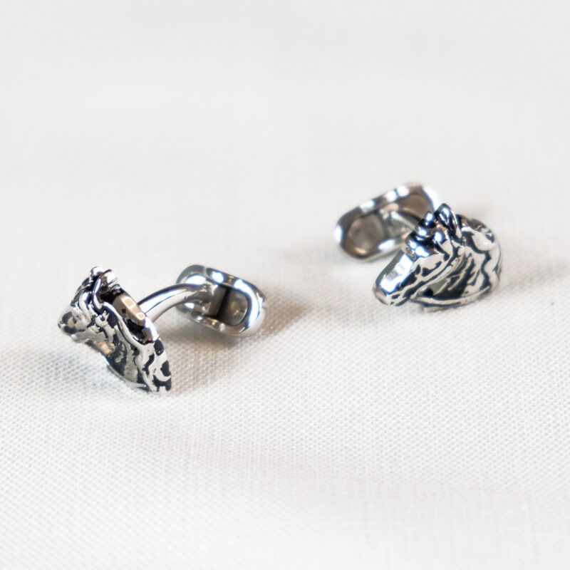 A pair of silver earrings sitting on top of a table.