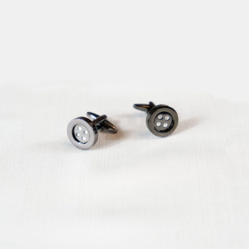A pair of black and white earrings sitting on top of a table.