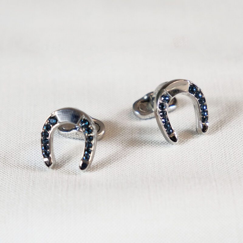 A pair of silver earrings with blue stones.