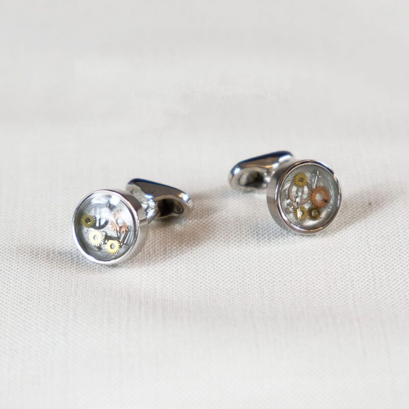 A pair of cufflinks with the image of a flower.