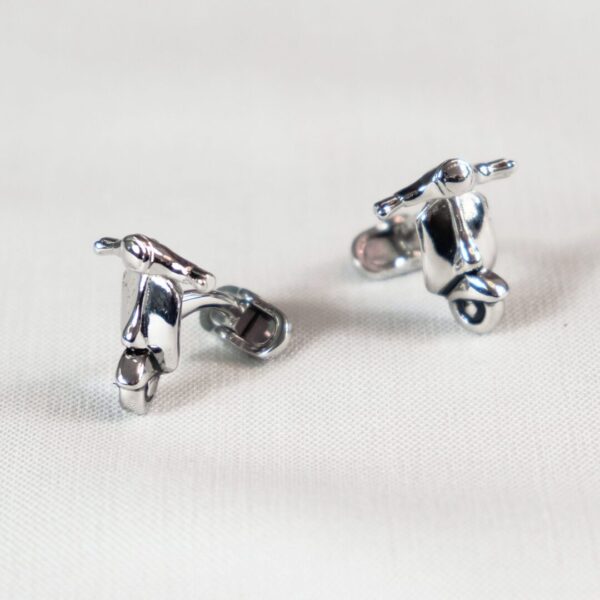 A pair of silver earrings sitting on top of a table.