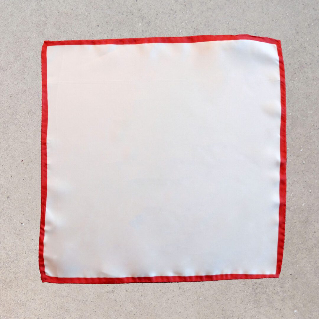 A white cloth with red trim on the edge of it.