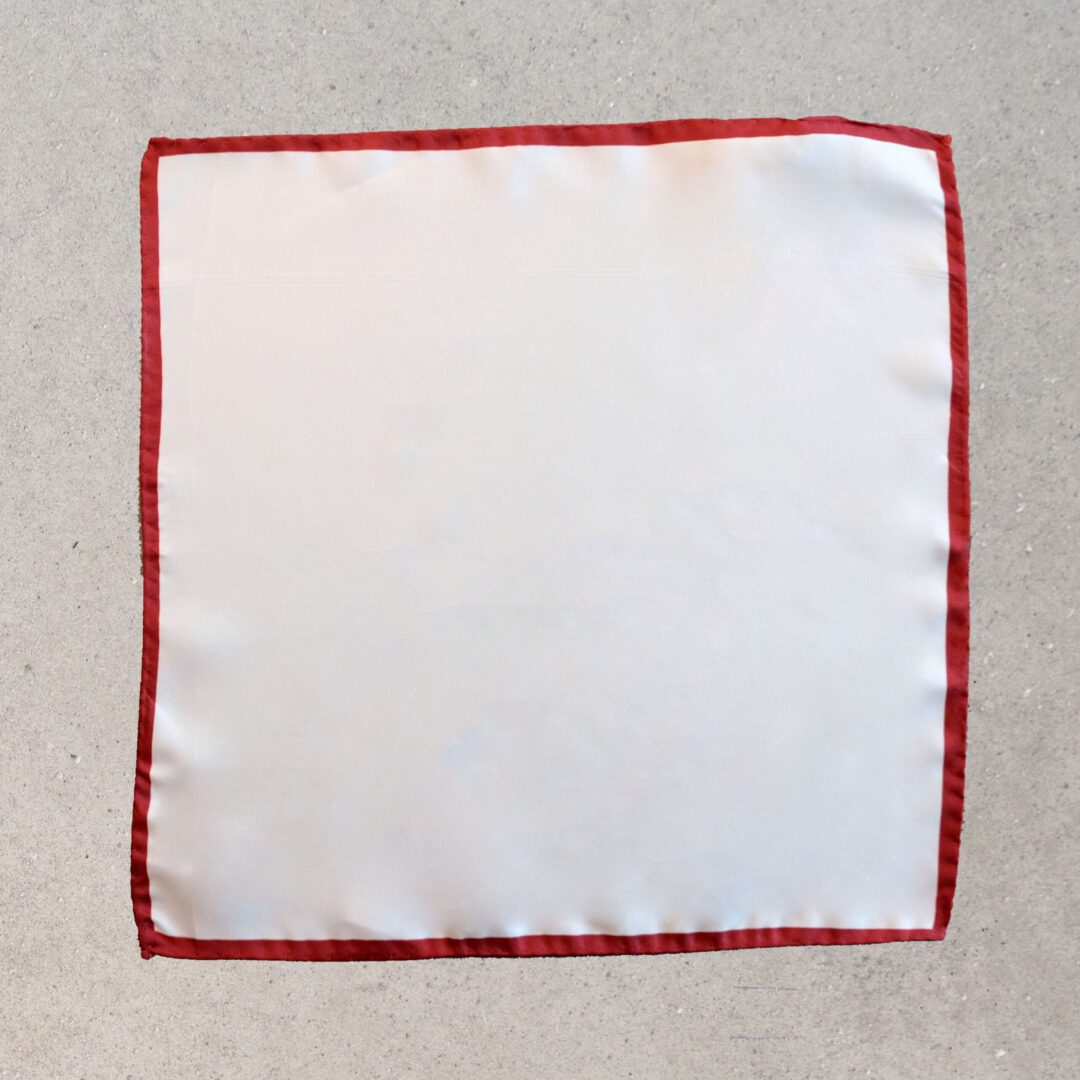 A white cloth with red trim on the edge of it.