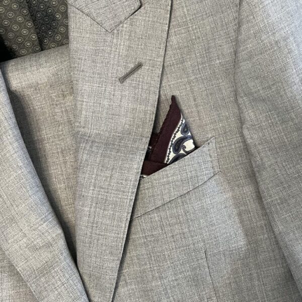 A suit jacket with a pocket square and a tie.