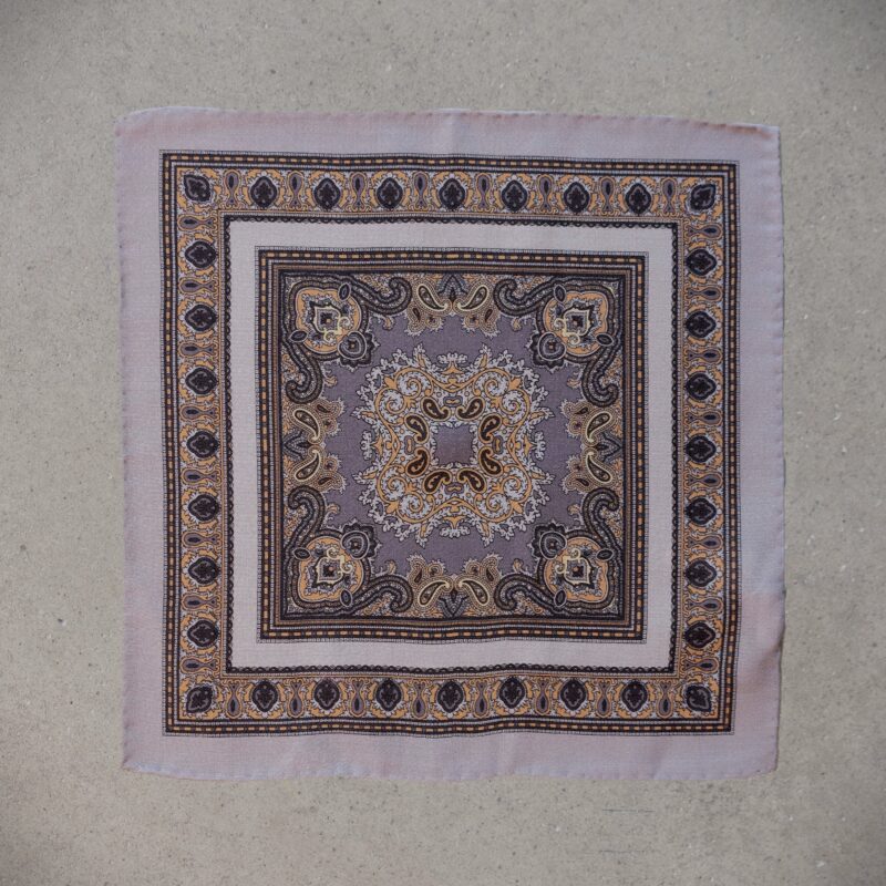 A square rug with a pattern of flowers and leaves.