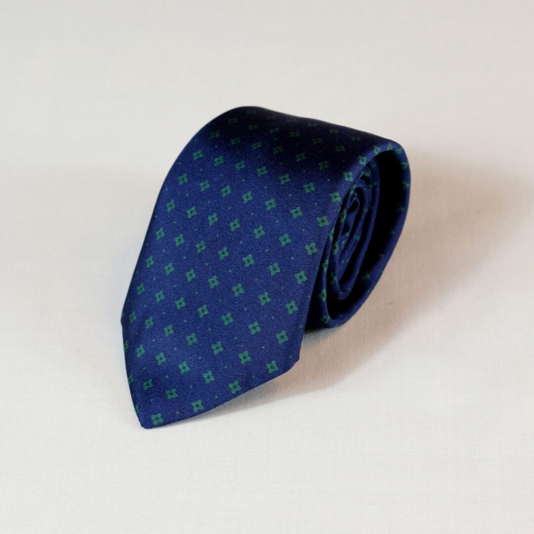 A blue tie with green polka dots on it