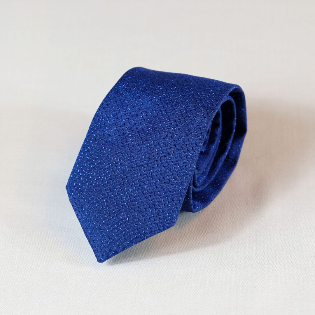A blue tie is laying on the floor.