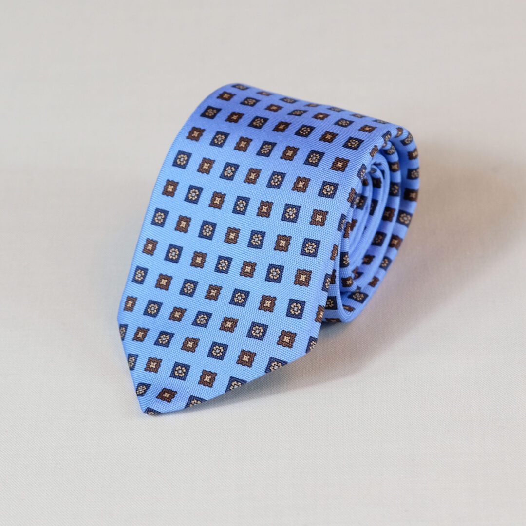 A blue tie with brown squares on it