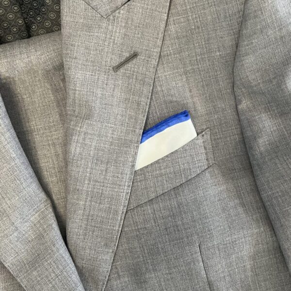 A suit jacket with a blue and white card in it.