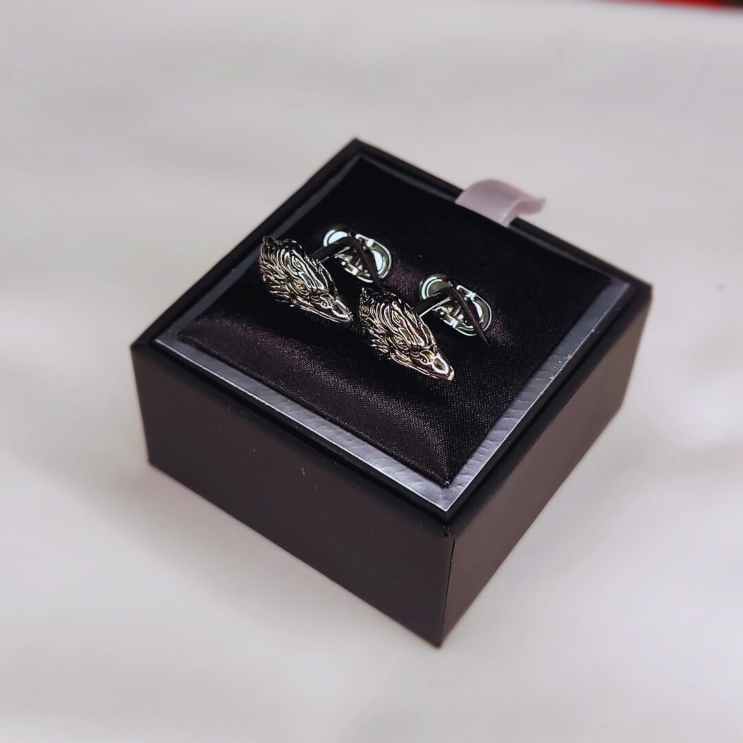 A pair of cufflinks in a box on top of a table.