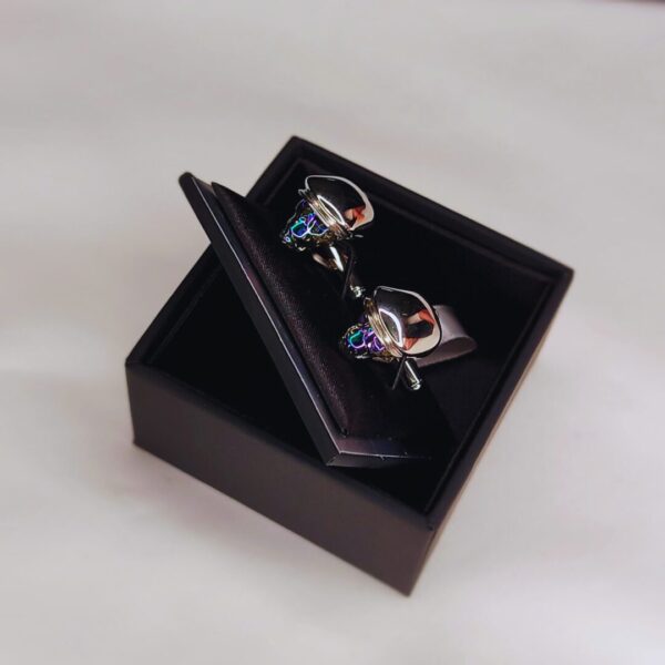 A pair of cufflinks in a box on top of a table.