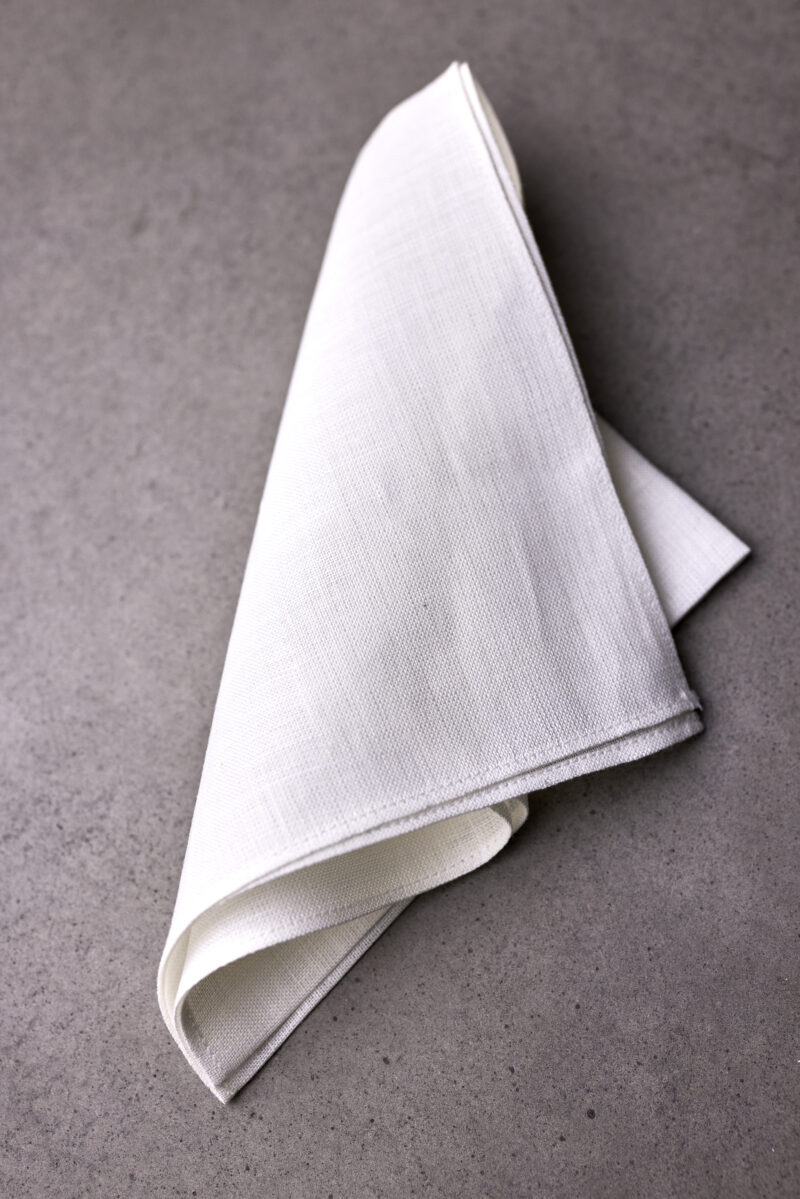 A folded white napkin on top of a table.