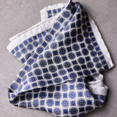 A folded blue and white patterned scarf on top of the floor.
