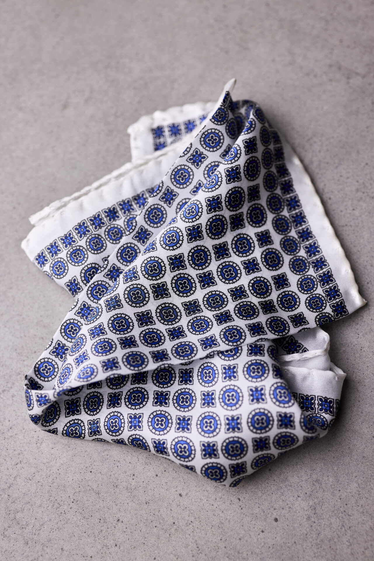 A folded blue and white patterned scarf on top of a table.