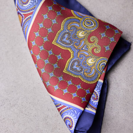 A folded red and blue paisley pocket square.