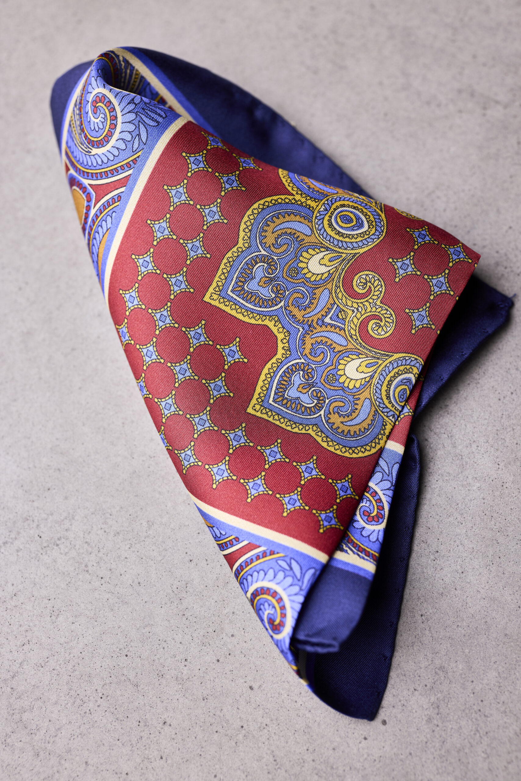 A folded red and blue paisley pocket square.