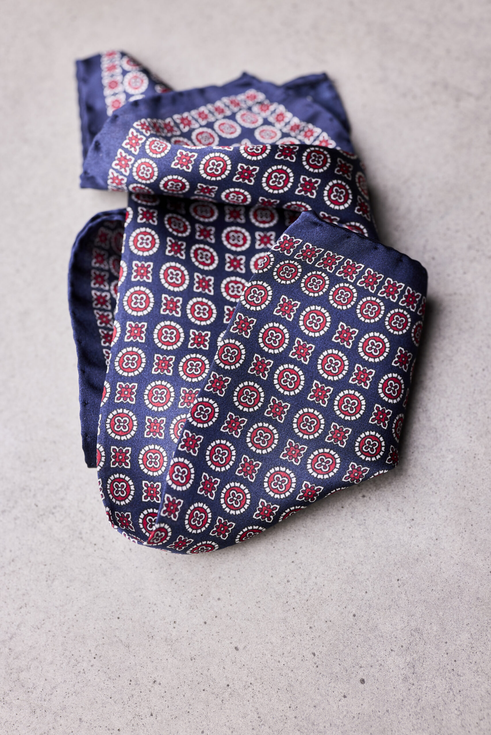 A folded blue and red tie on top of the floor.