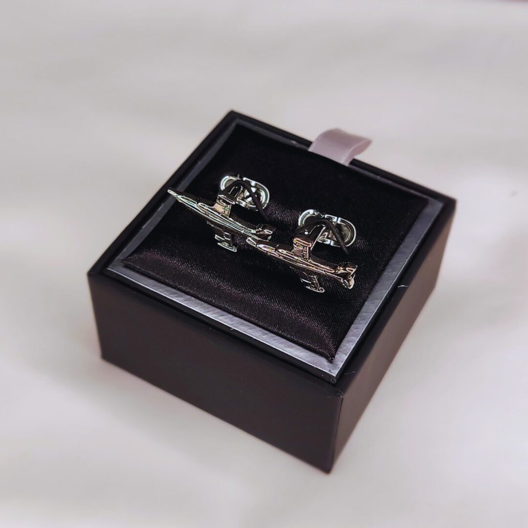 A wooden box with a pair of cufflinks in it.