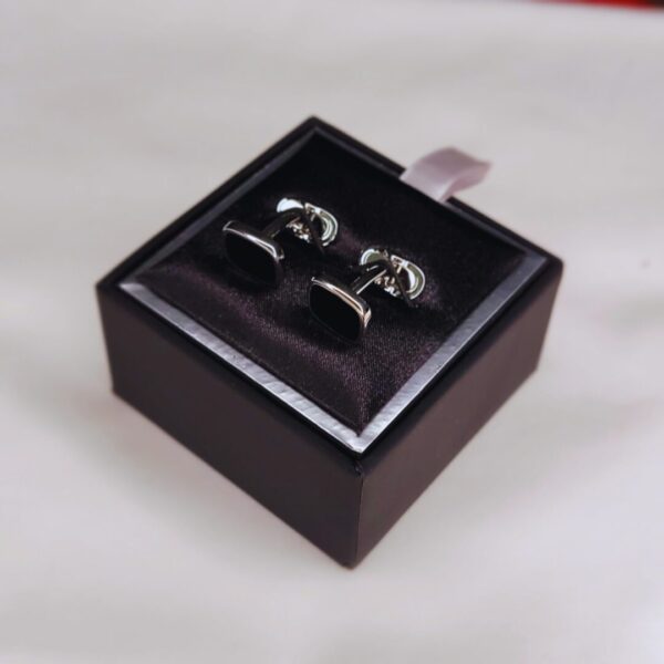 A pair of silver cufflinks in a box.