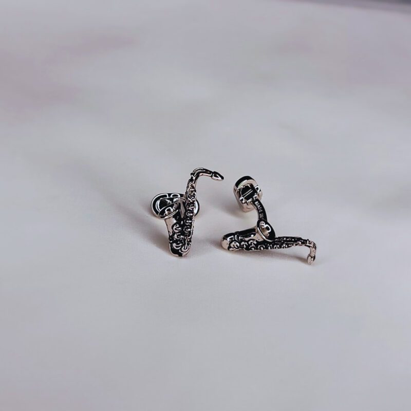 A pair of silver earrings sitting on top of a table.