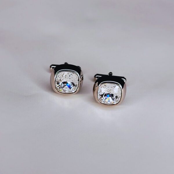 A pair of cufflinks with a square shaped diamond.