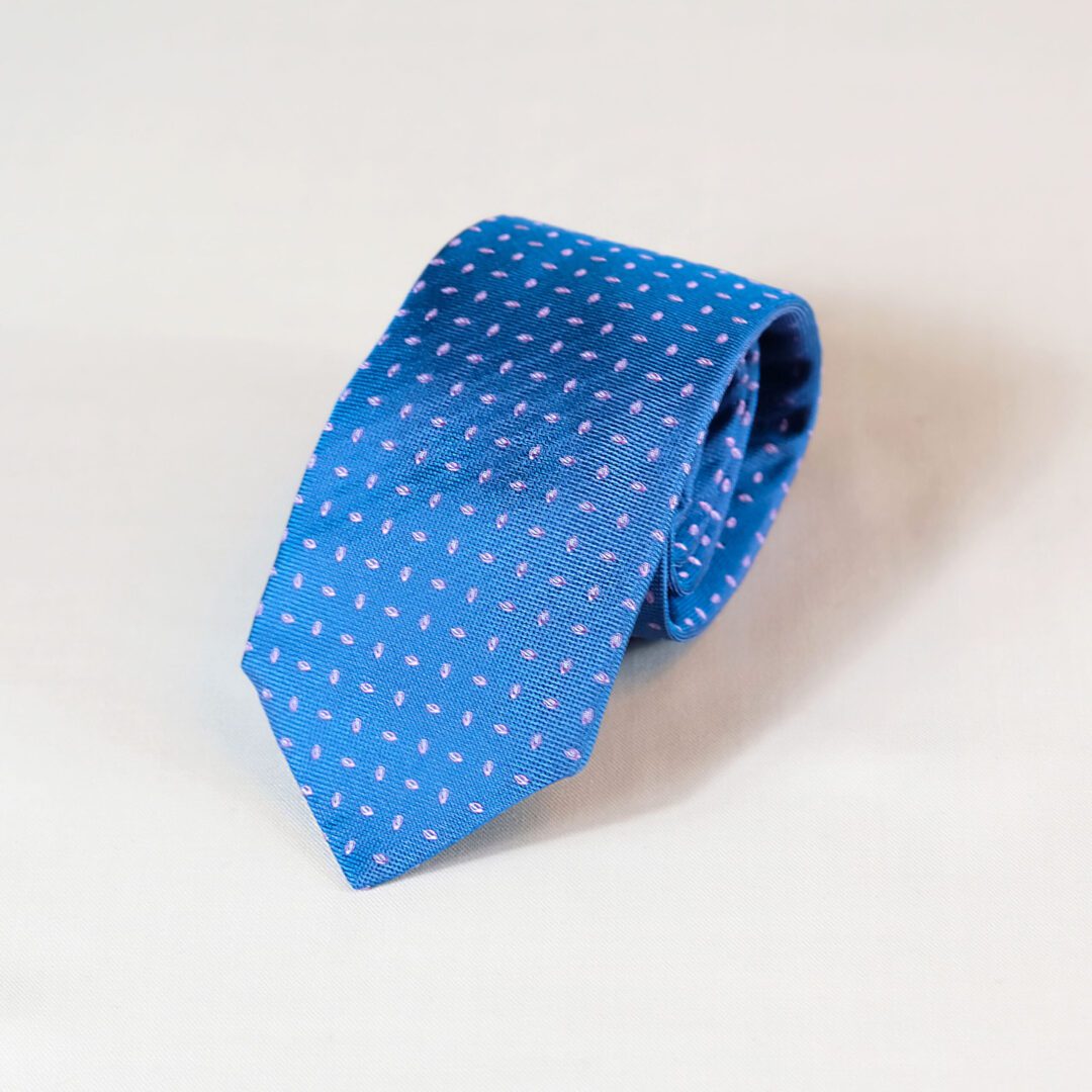 A blue tie with white polka dots on it.