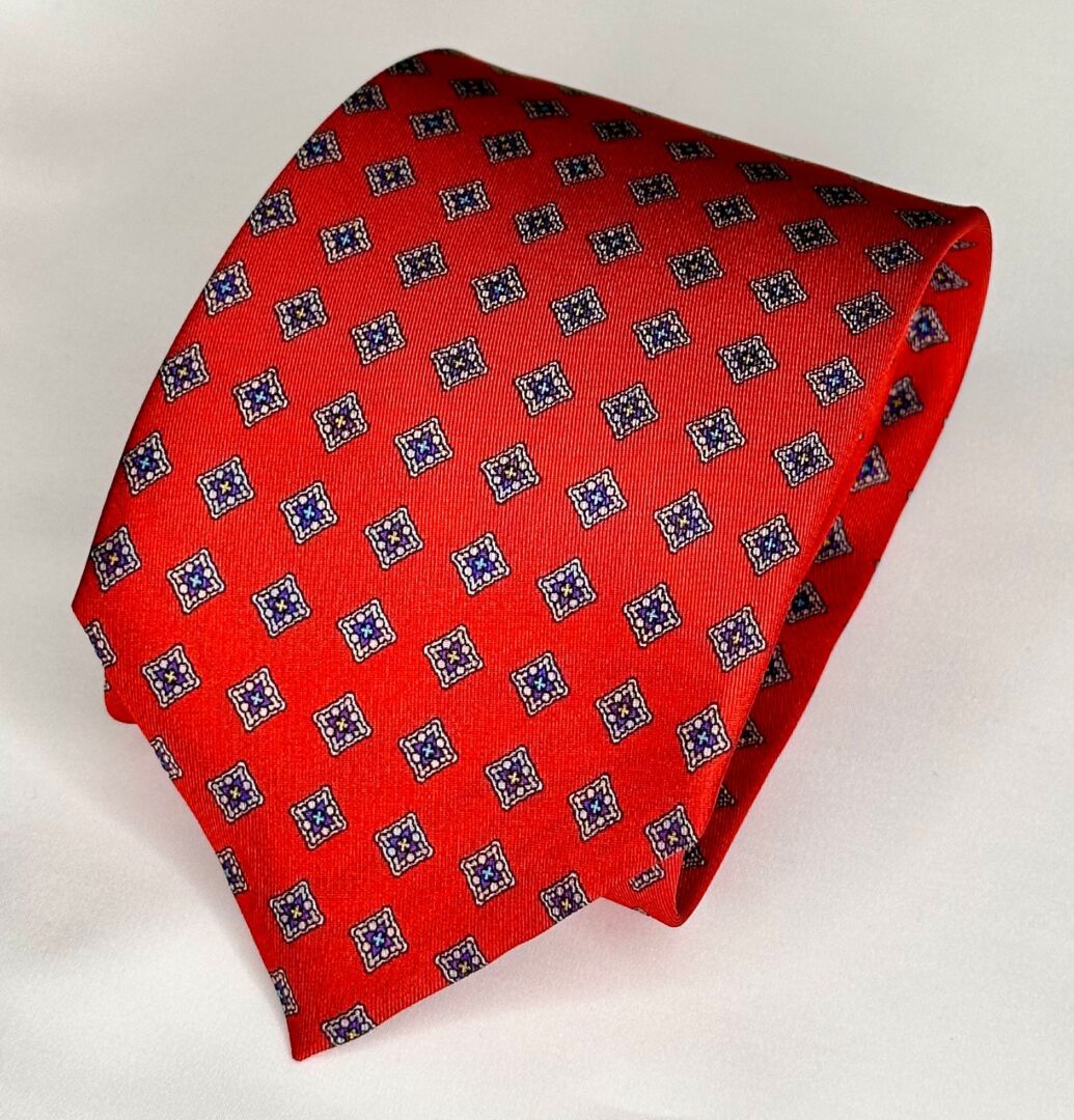 A red tie with blue and white squares on it.