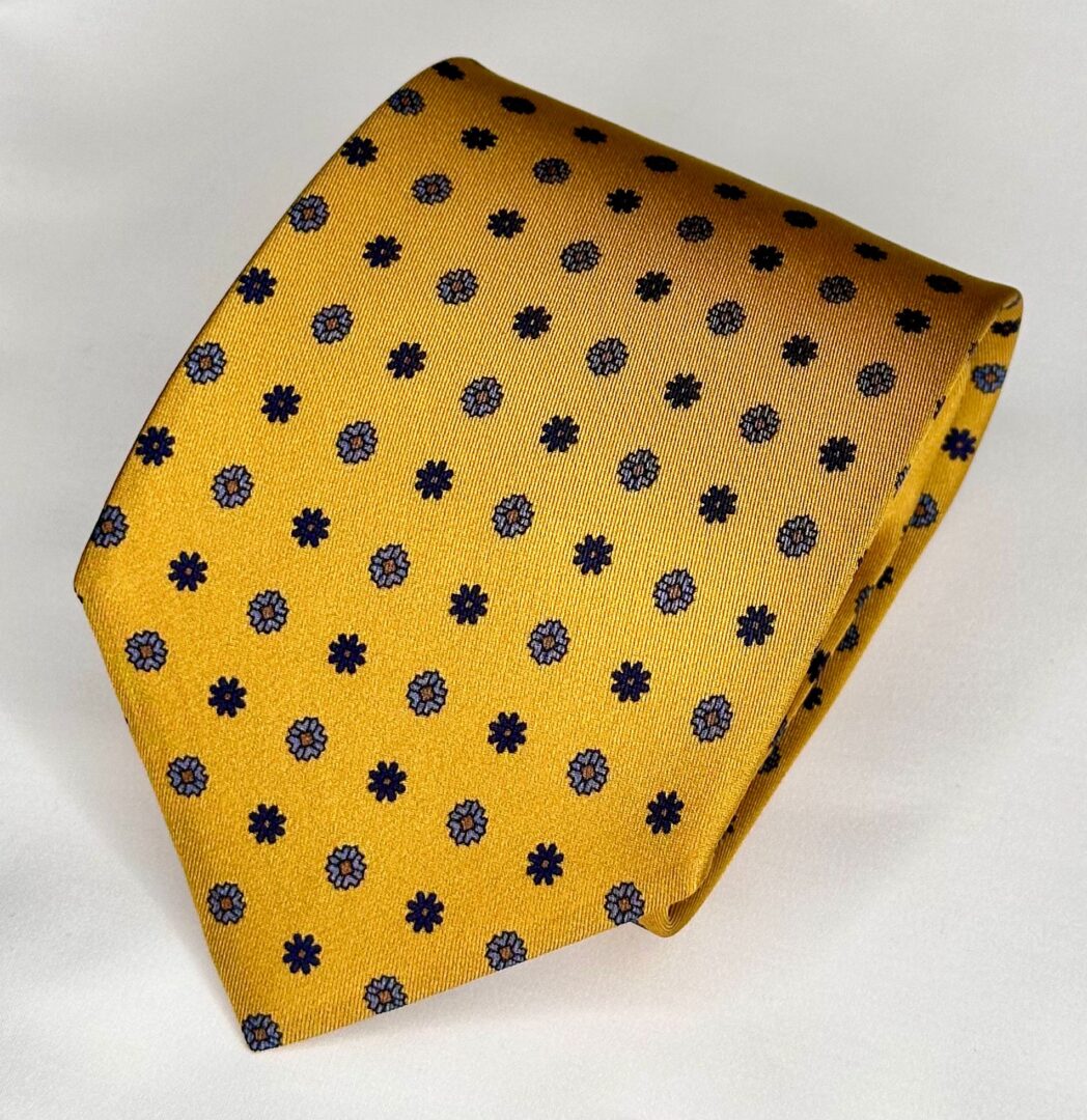 A yellow tie with black polka dots on it