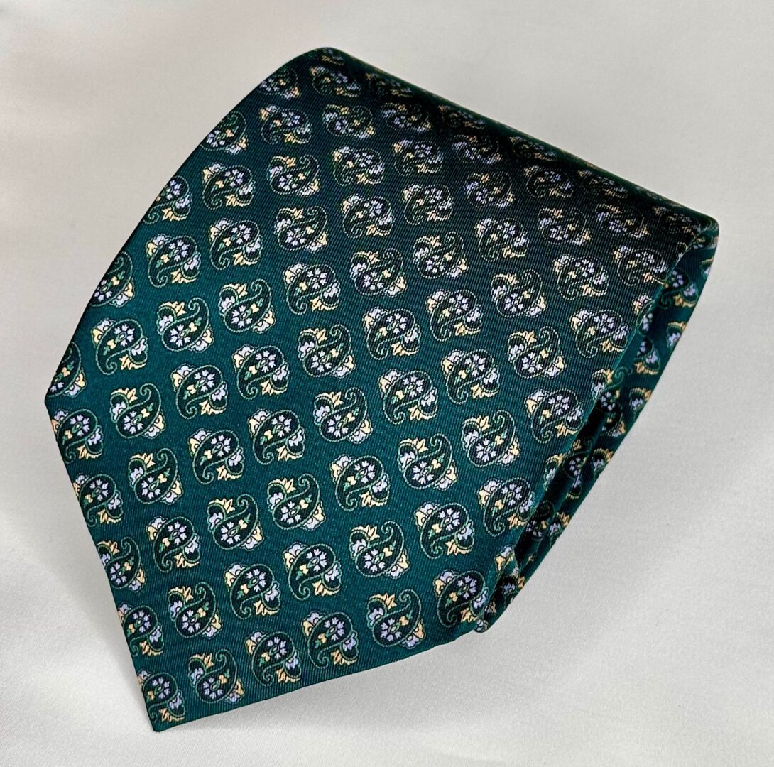 A green tie with white and black flowers on it